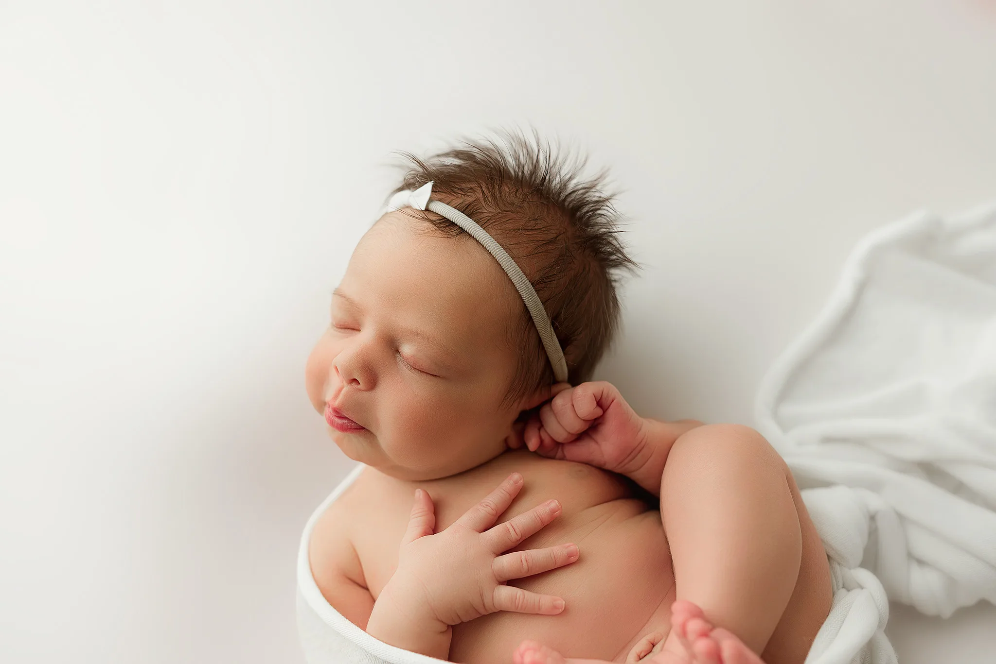 newborn girl posed on white during newborn session, baby girl newborn poses, nebraska photographer, luxury lincoln nebraska