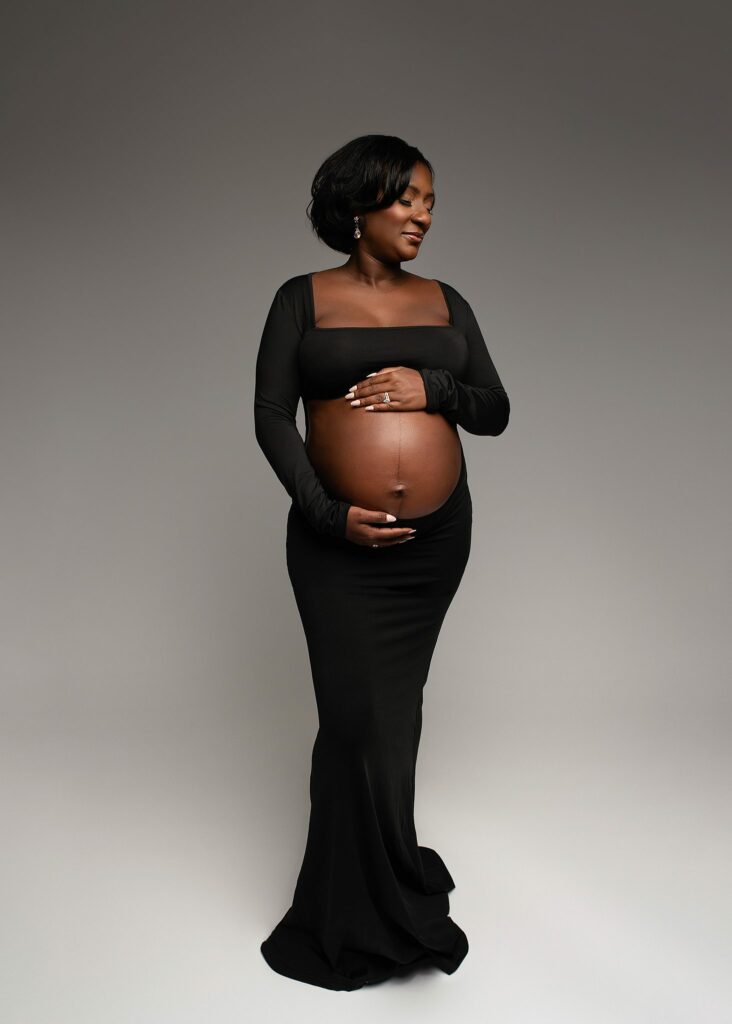 Mom posed with hands on belly while she dreams of her baby boy, mom pregnant with baby boy, mom by herself during photoshoot, maternity photography georgia