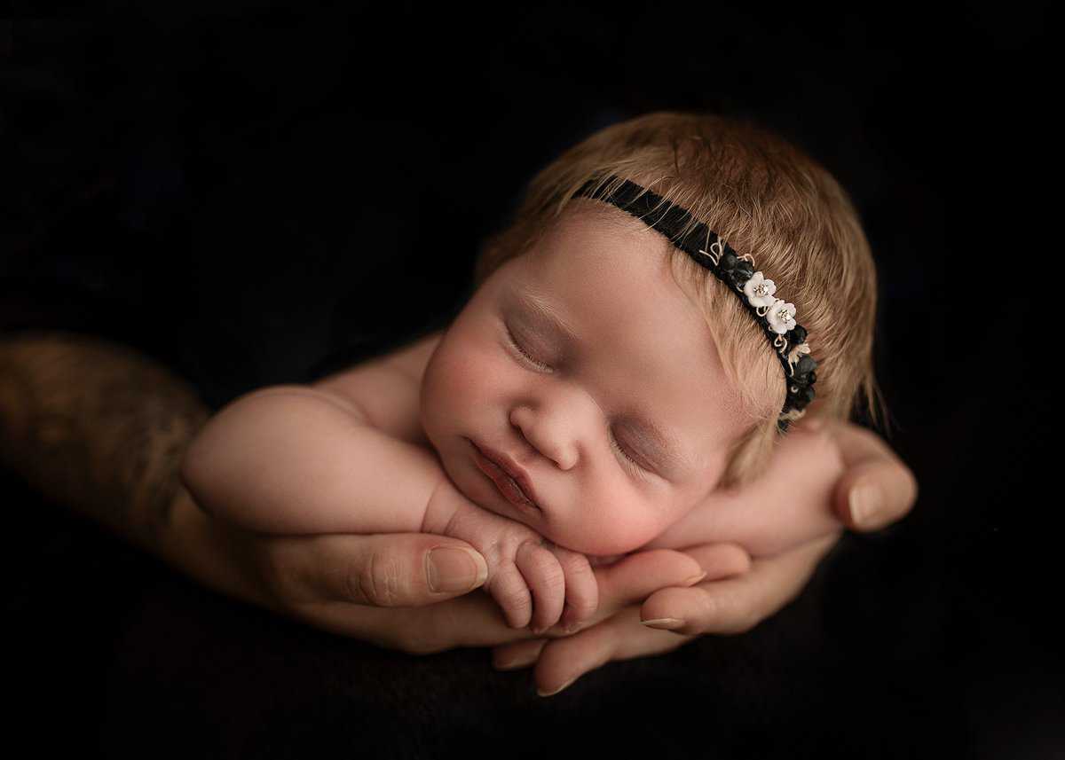 newborn on parents hands, black tieback, sleeping baby, baby portraits, acworth newborn photographer, studio newborn photography georgia, luxury newborn photographers, professional newborn photography near me, newborn photography prices