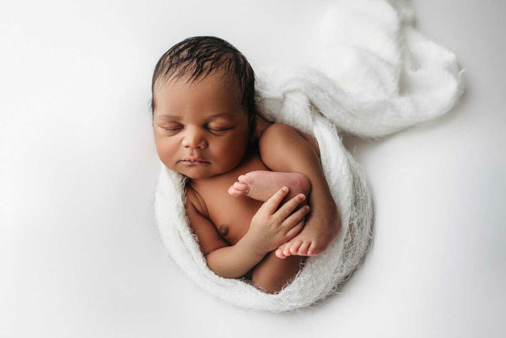 baby boy photographed on white for his newborn photography session in Atlanta ga, newborn portraits atlanta, natural newborn poses, atlanta newborn photography, white newborn set ups