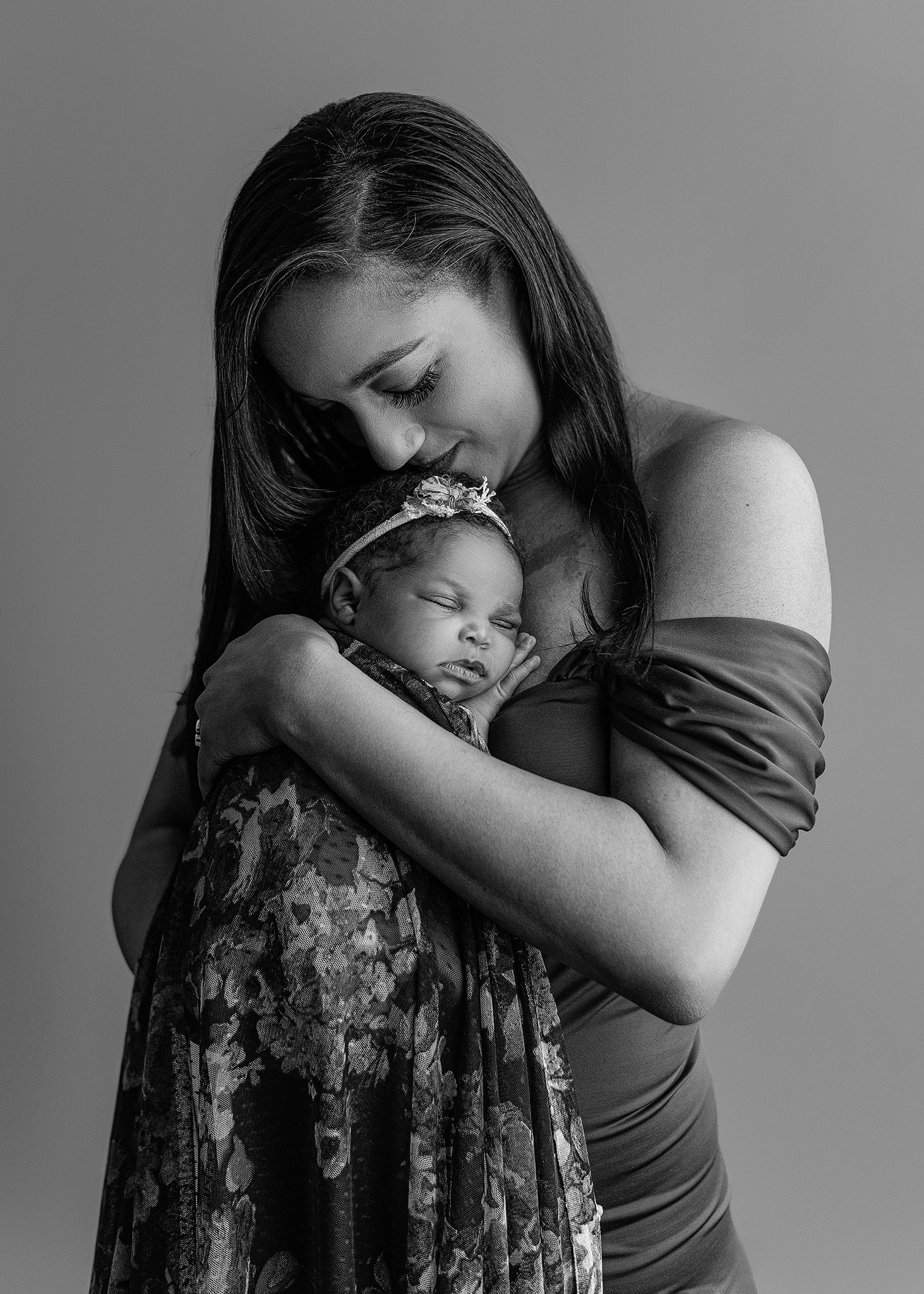 mom holding her baby girl and embracing the moment during her georgia newborn photo session