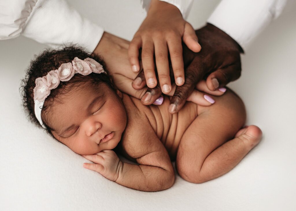 newborn baby girl sleeping while mom, dad and brother place their hands on her back. Timeless newborn poses, atlanta newborn photography studio newborn girl session