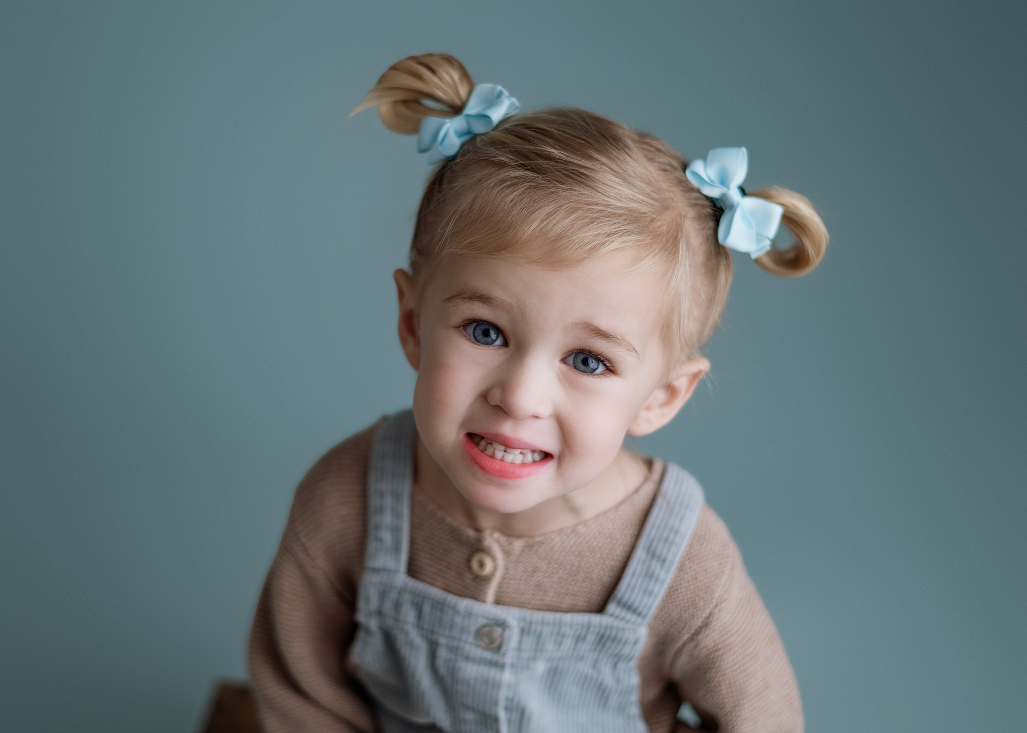 3 year old girl posed on blue for milestone session, baby photographer lincoln ne, lincoln ne family photography, nebraska photographers
