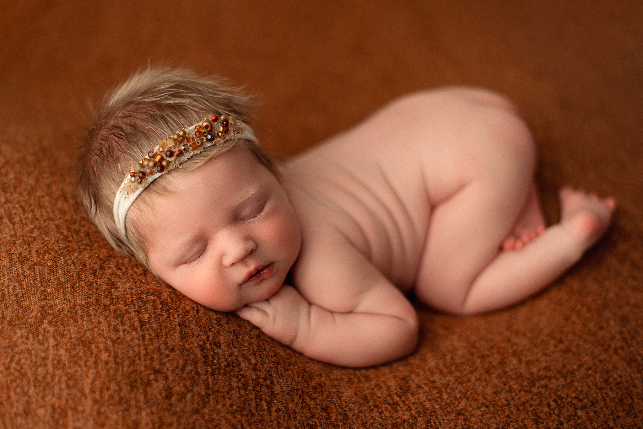 newborn baby professional photoshoot, simple newborn poses, newborn girl with blonde hair on orange backdrop, omaha newborn photographer