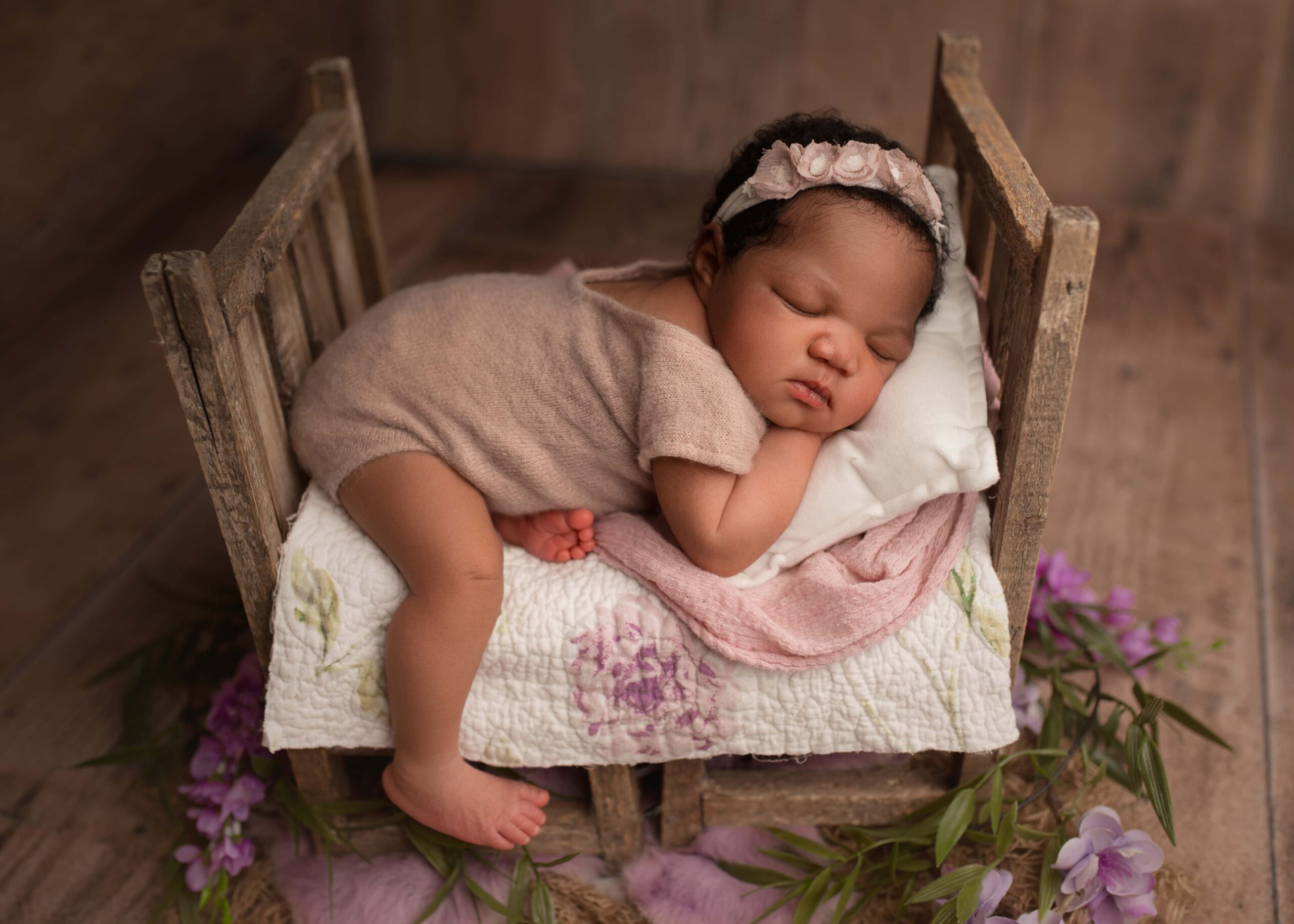 newborn girl posed on prop bed for photography session, purple newborn set up, lincoln nebraska newborn photographer, nebraska newborn photoshoot
