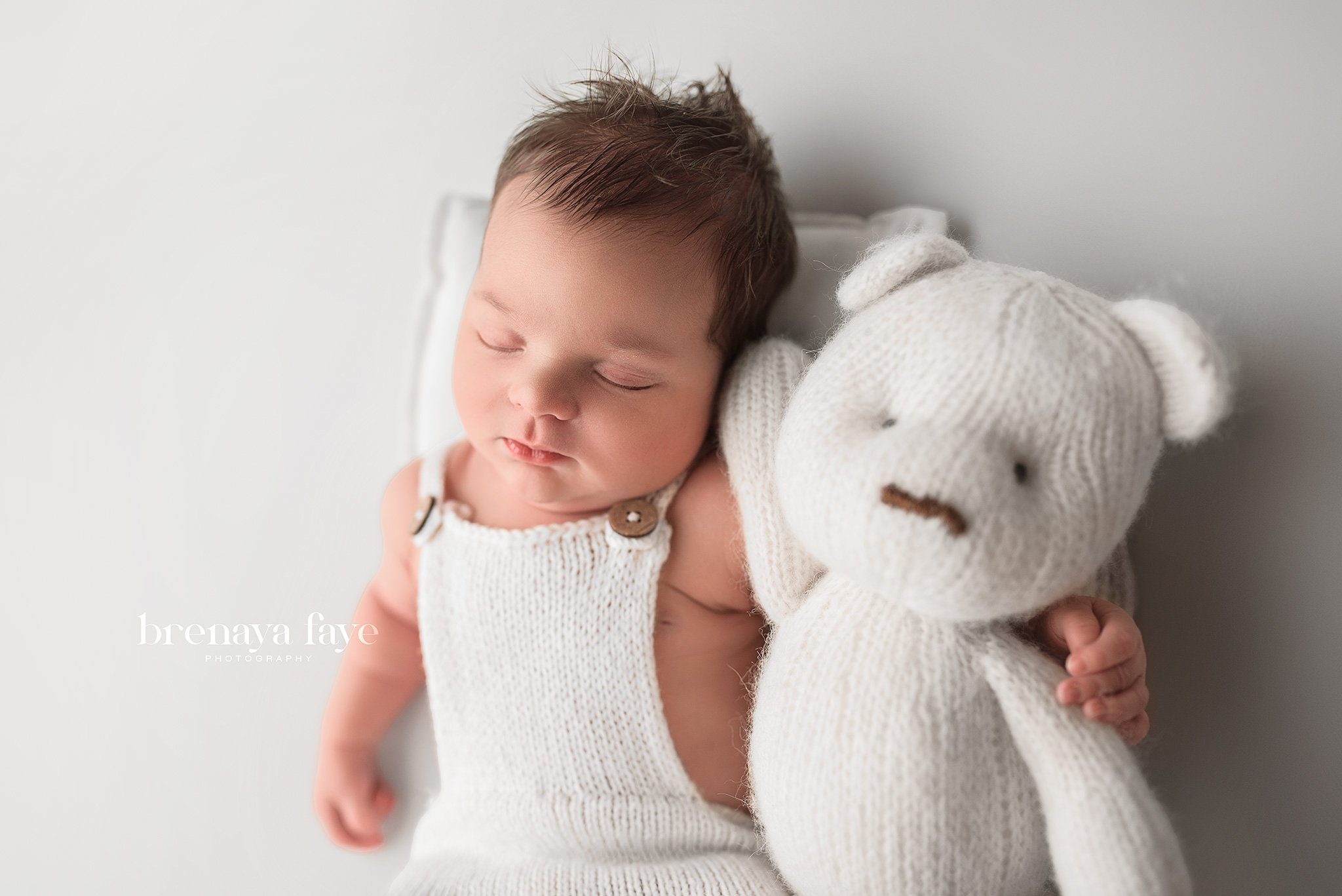 newborn boy posed on white backdrop with bear prop, newborn photography near me, lincoln nebraska photographer