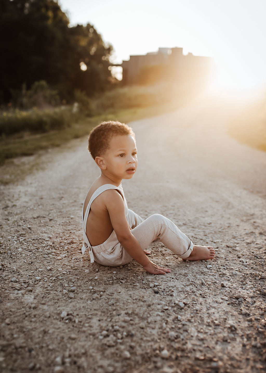 little boy looking to side while playing in the rocks with the sun shining, beatrice family photography