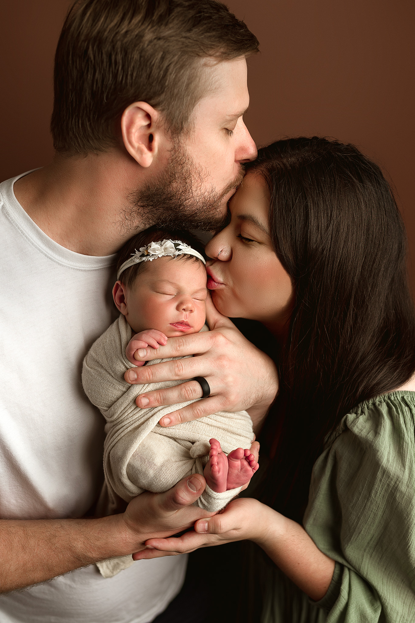 mom and dad posed in studio for newborn photography session, studio newborn photographer, green dress, newborn girl photo ideas, tieback