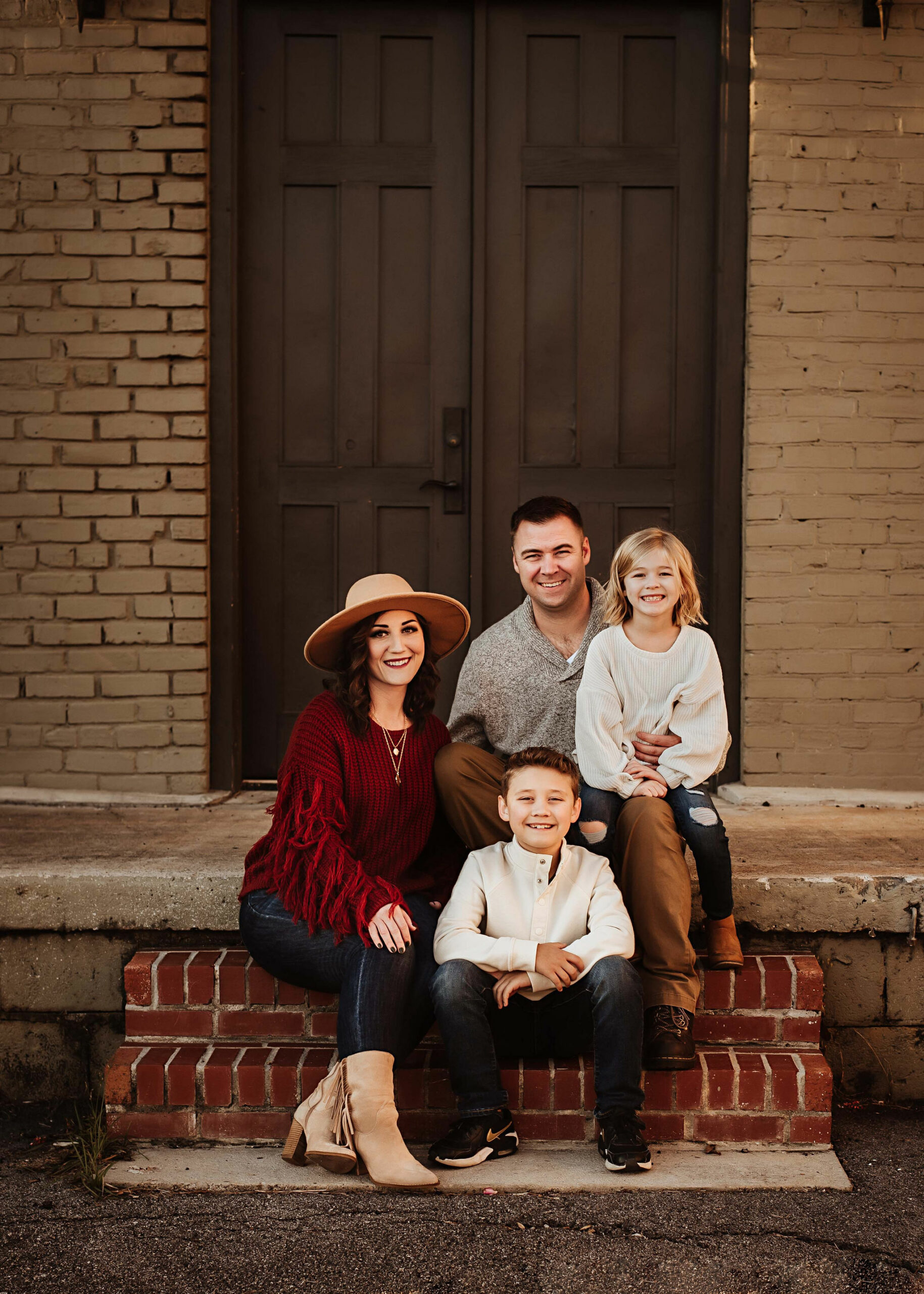 family sitting on brick stairs for their photography session with brenaya faye photography