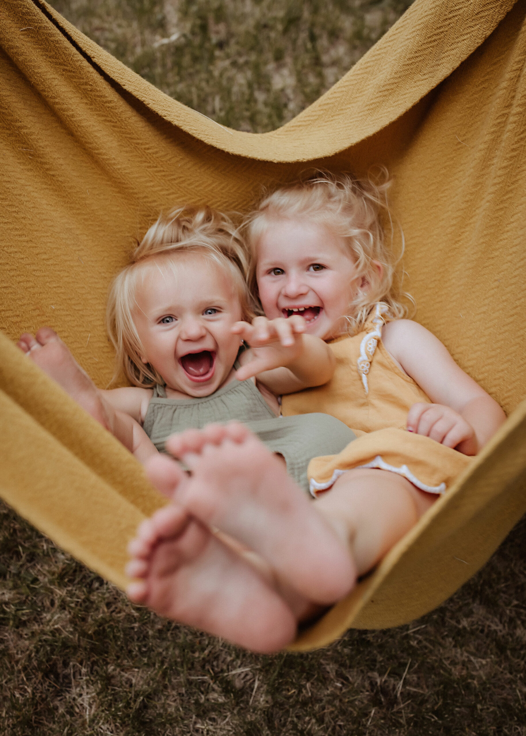 sisters on blanket having fun for photography session in nebraska