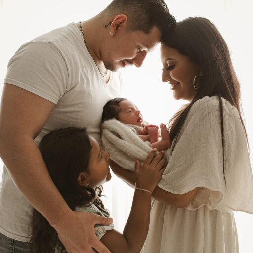 candid newborn photos, cream newborn session, newborn with mom and dad, backlit family pose ideas