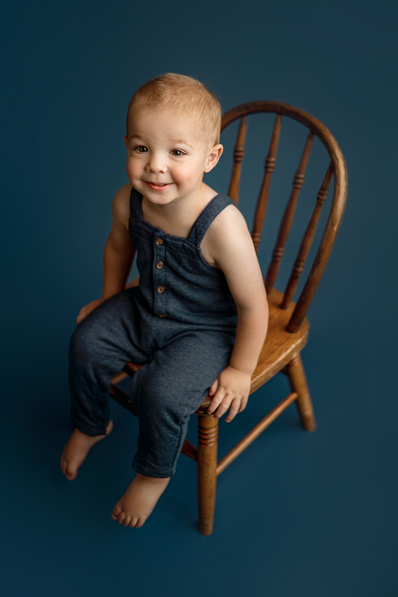 18 month old boy blue photoshoot, boy sitting on chair during photo session, lincoln nebraska milestone photographer, studio photography nebraska