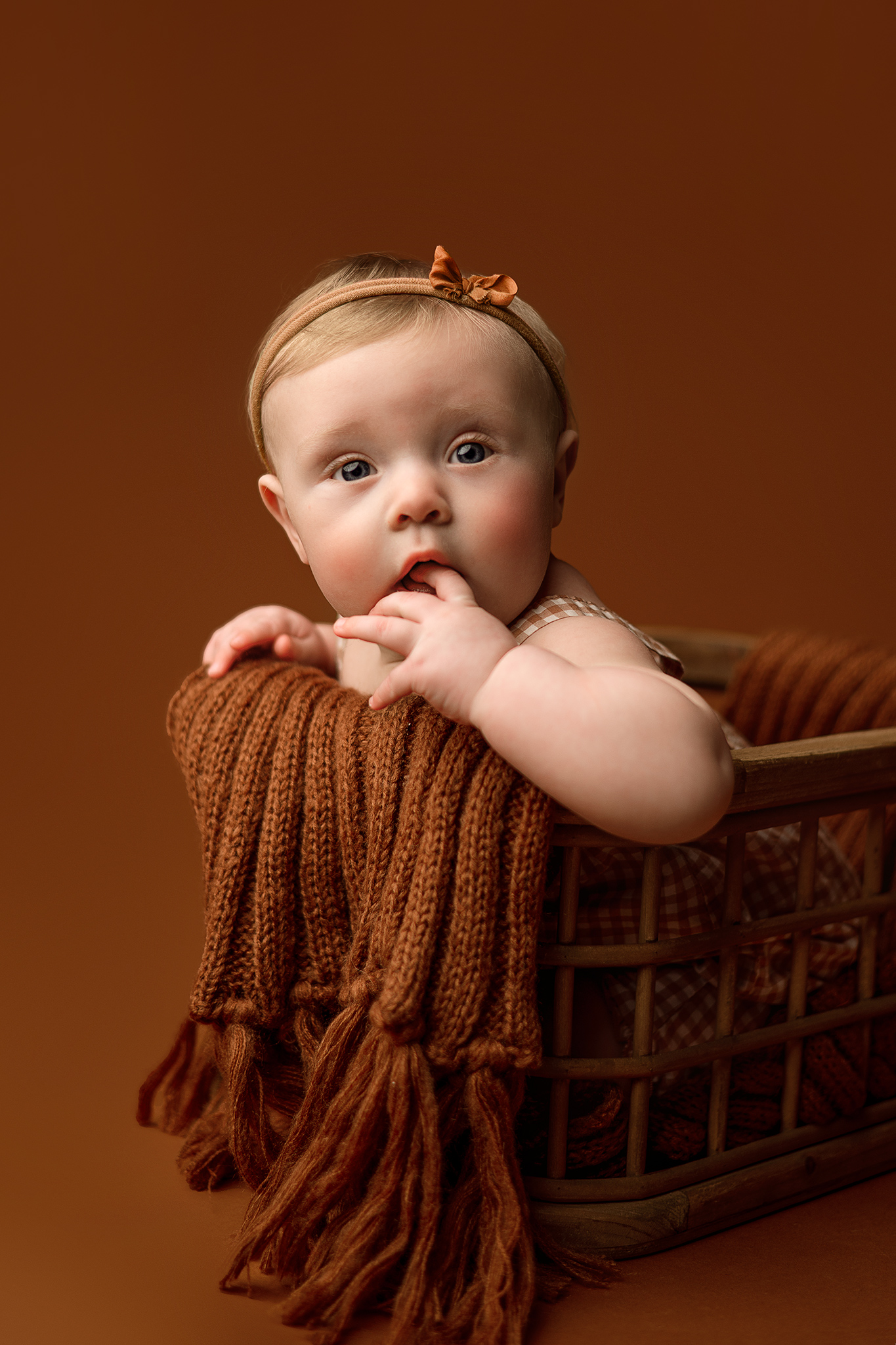 baby in brown bucket for photoshoot, nebraska child portraits, portrait photographer nebraska