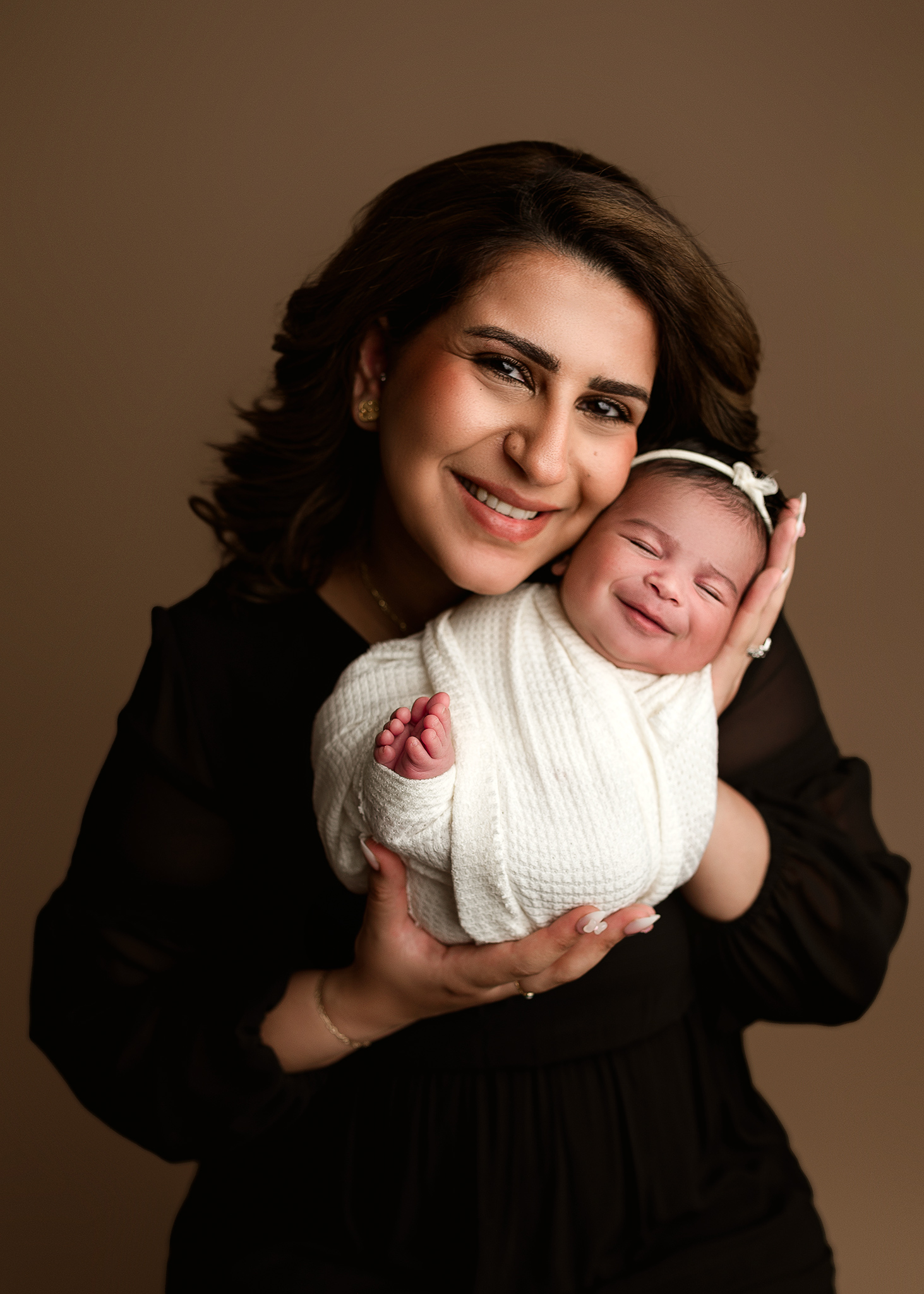 mom and baby girl smiling for parent poses, parent pose ideas, neutral newborn photoshoot