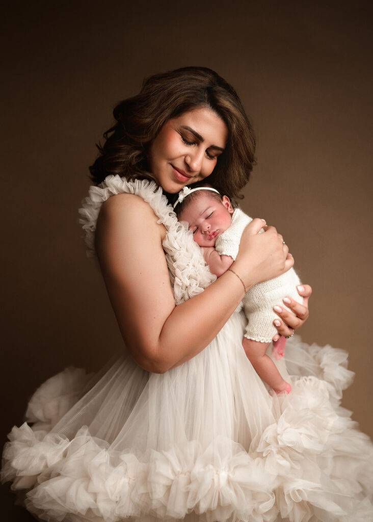 mom snuggling with baby girl for newborn photography session in omaha nebraska, lincoln nebraska newborn photographer studio