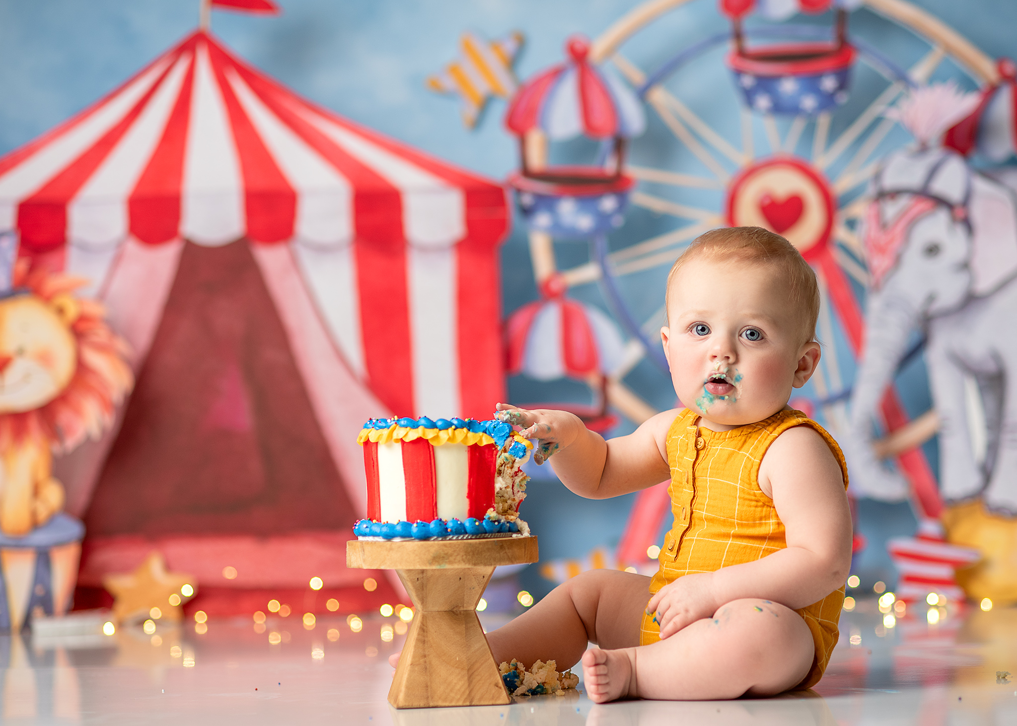 birthday boy celebrating with a cake smash, circus themed cake smash, red cake smash themes, primary color cake smash, smash cake lincoln nebraska