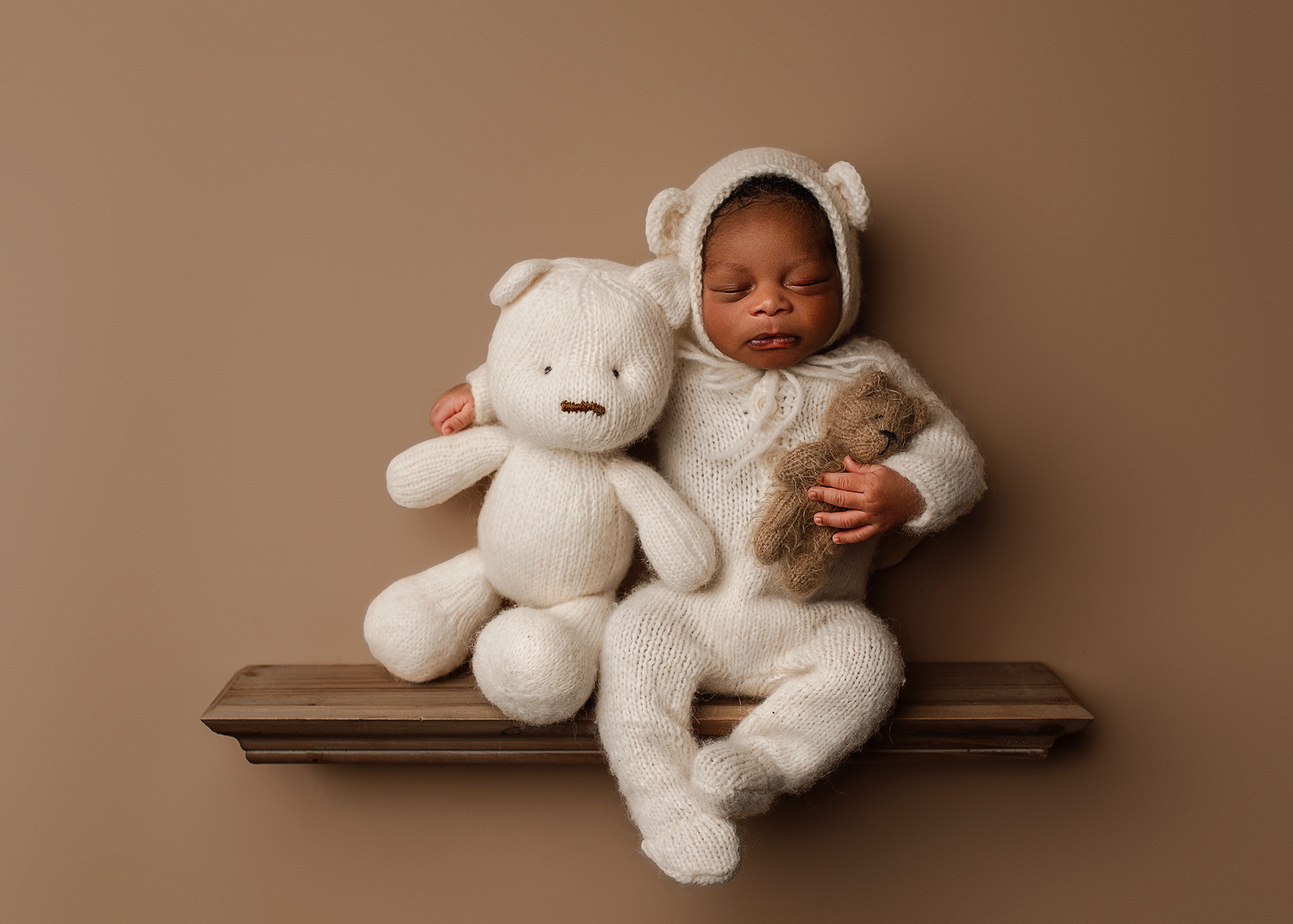 Newborn posed with a teddy bear, newborn on shelf, fun newborn photoshoot ideas, black newborns, newborn portraits