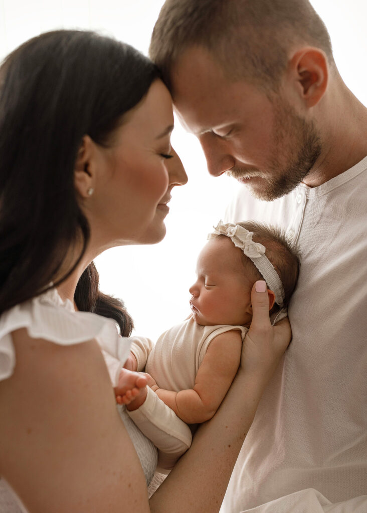 mom and dad posing with newborn baby girl in west lafayette photography studio, Luxury photography studio, fine art portraits