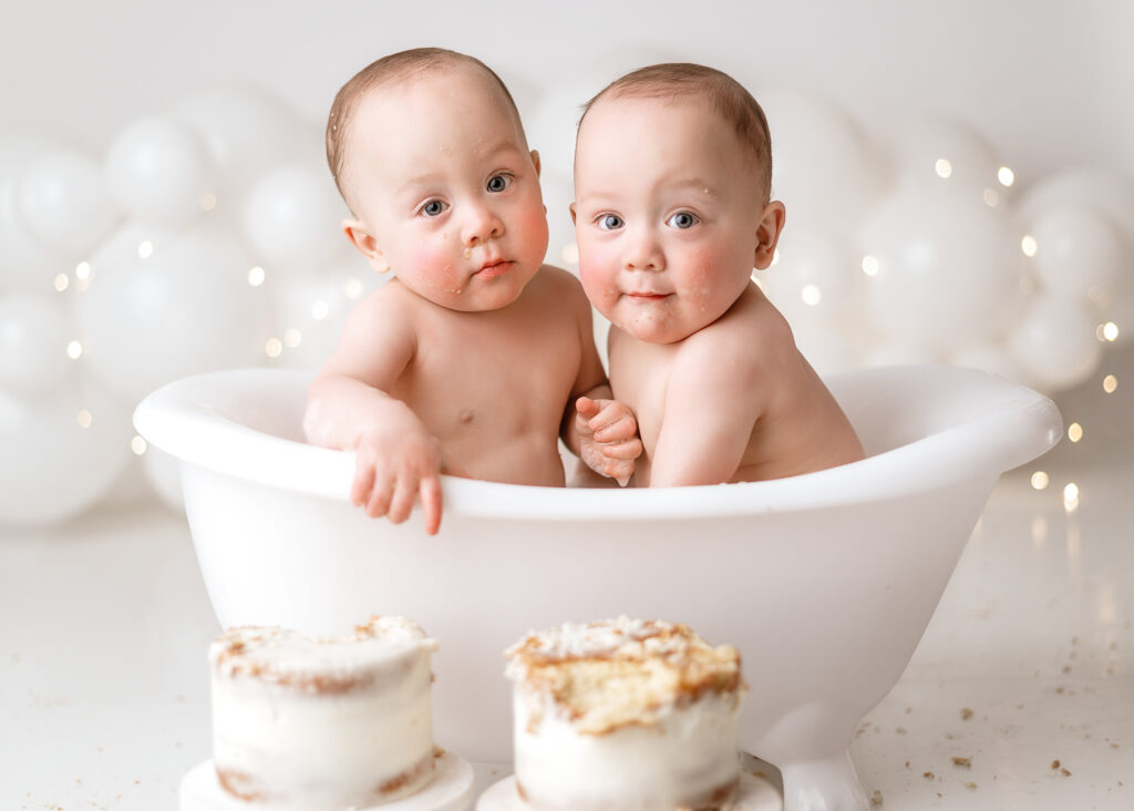 sweet twin boys looking into the camera during their cake smash session with west lafayette photographer