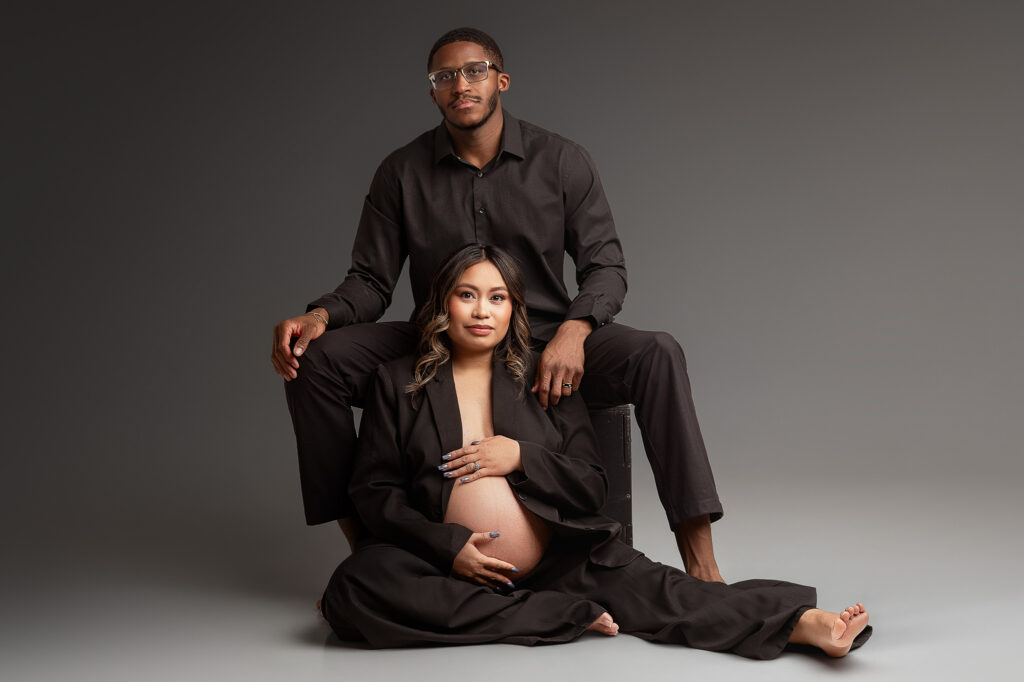 husband and wife photographed in black for a modern maternity session in lafayette indiana