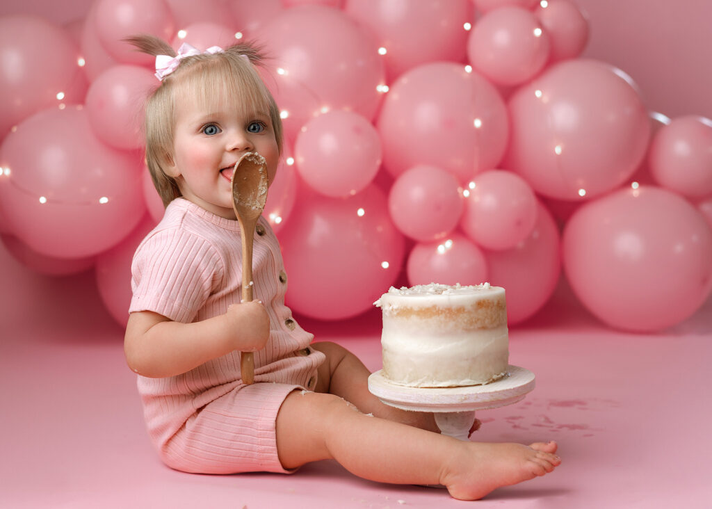 baby girl smiling for her cake smash for her first birthday photoshoot in west lafayette