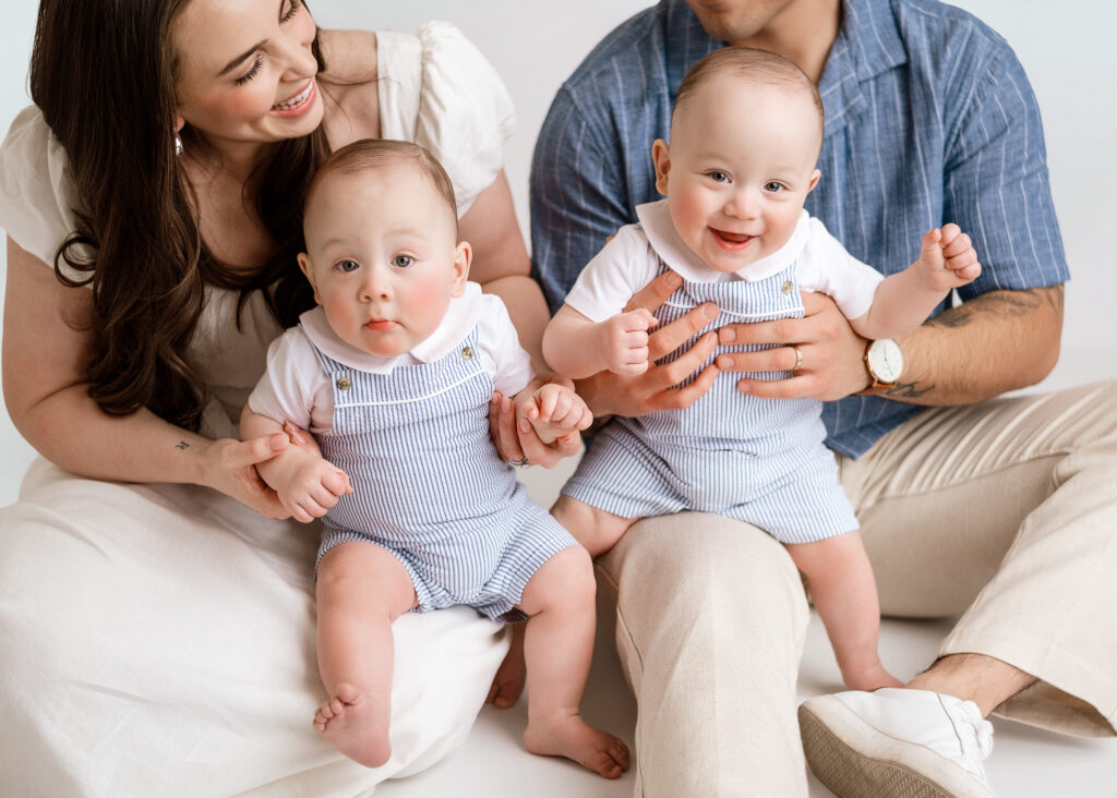 Family of 4 smiling while being photographed during in home session in west lafayette