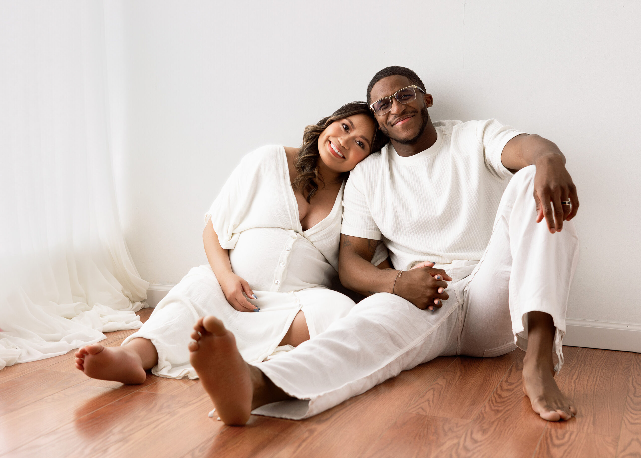 parents to be sitting on floor during maternity photoshoot in indiana