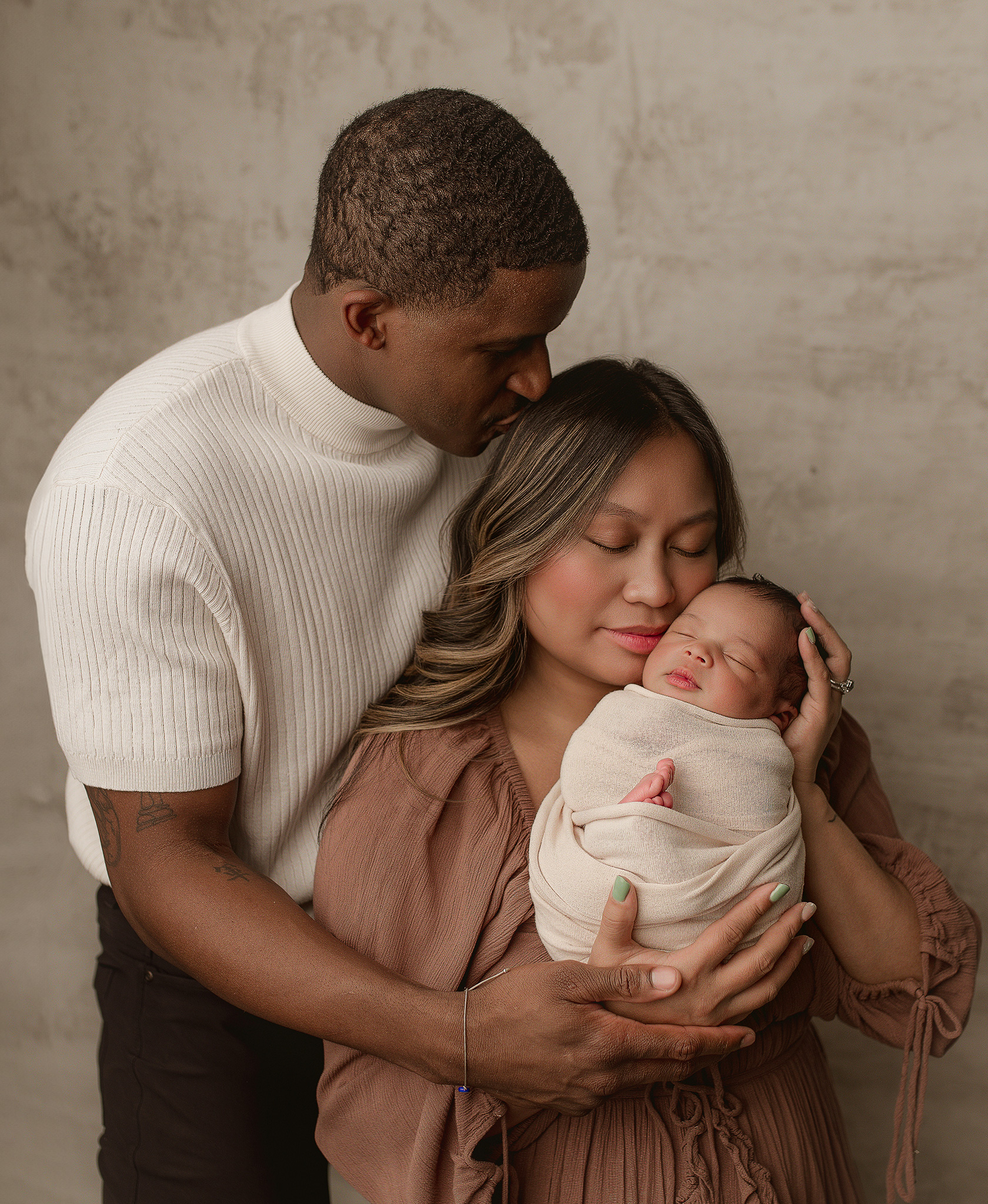 mom and dad posed in their home with their newborn baby boy for his newborn session in indianapolis