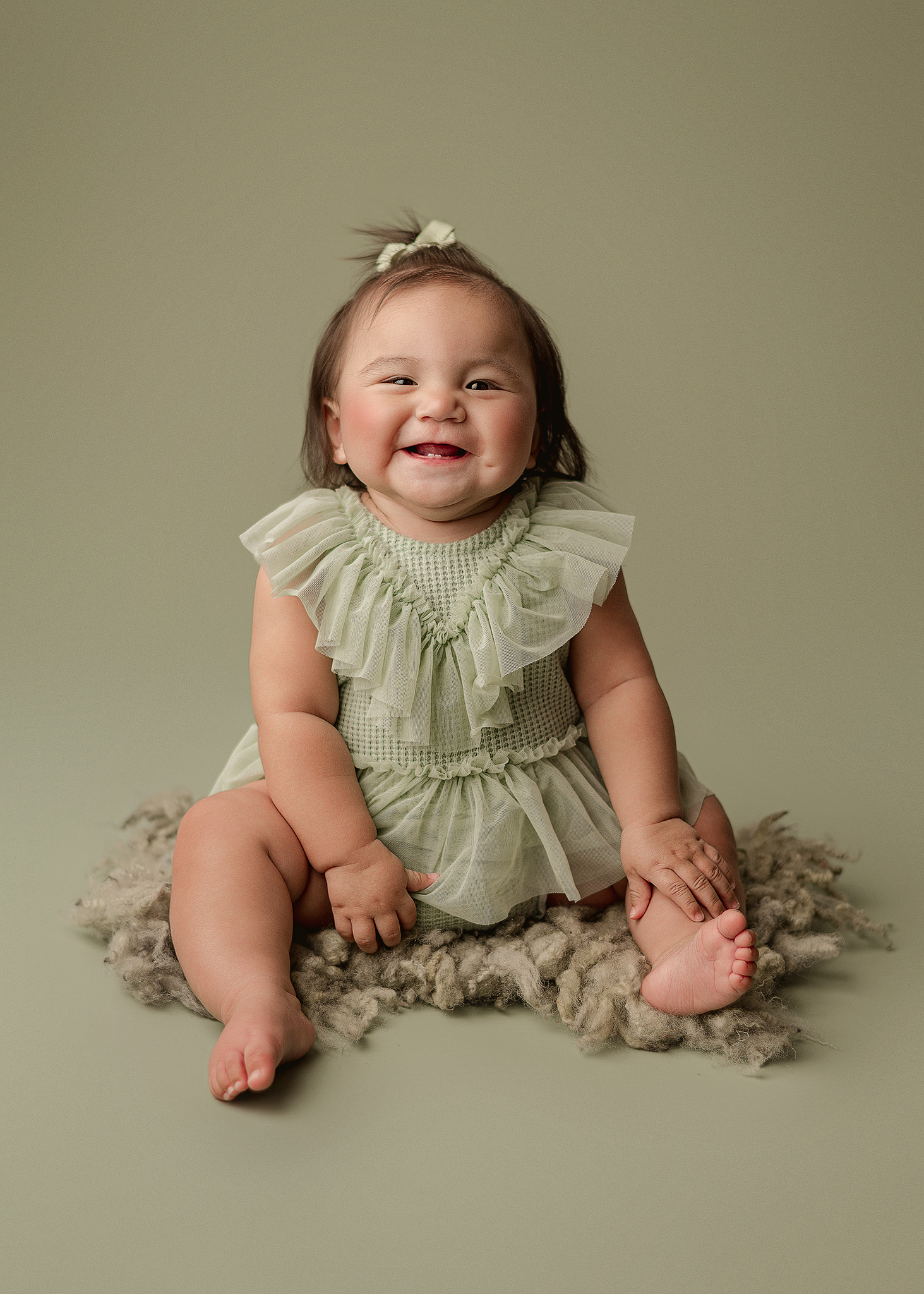Natural smiles and sweet expressions during a baby girl's milestone photography session